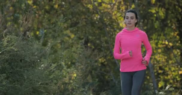 Красивая спортсменка в розовой спортивной одежде бег трусцой на открытом воздухе, концепция здорового образа жизни — стоковое видео