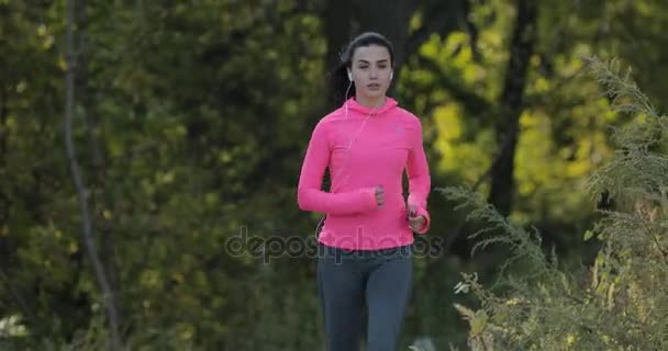 Bastante deportista en ropa deportiva rosa corriendo al aire libre, concepto de estilo de vida saludable — Vídeo de stock