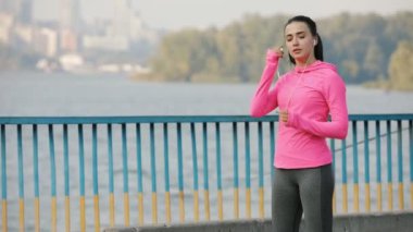 Açık havada bir köprüde, sağlıklı yaşam konsepti koşu pembe spor giyim güzel sporcumuz. Ağır çekim.