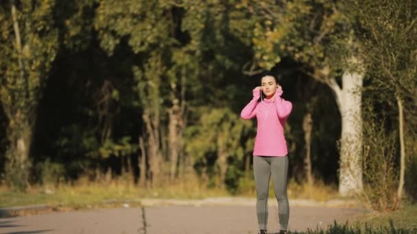 Bastante deportista en ropa deportiva rosa corriendo al aire libre, concepto de estilo de vida saludable. Movimiento lento . — Vídeo de stock