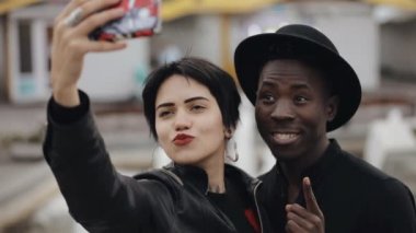 Beyaz kadın ve zenci çift Slowmotion selfie smartphone geçici video. Onlar gülümseyen yapması, birlikte gülüyor.