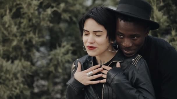 Movimento lento de namoro mulher branca e casal homem negro. Ele abraçando-a, eles sorrindo, falando, rindo juntos . — Vídeo de Stock