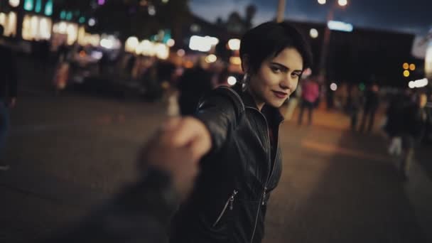 Rallentamento della donna mi seguono tenendo la mano maschile guardando alla fotocamera durante la notte — Video Stock