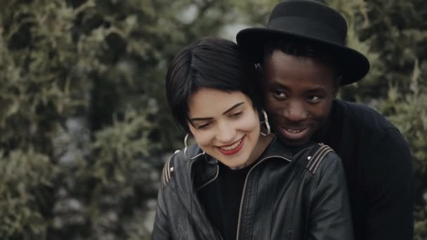 Movimento lento de namoro mulher branca e casal homem negro. Ele abraçando-a, eles sorrindo, falando, rindo juntos . — Vídeo de Stock