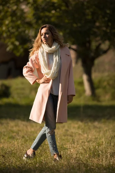 Retrato de comprimento total de mulher na moda em pé casaco e posando no parque de outono — Fotografia de Stock