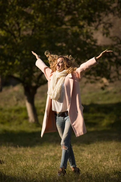 Ολόσωμο πορτρέτο του χαμογελαστό γυναίκα στην φθινοπωρινή μέρα στο πάρκο, αυτή απολαμβάνοντας φθινοπωρινή μέρα με υψωμένα τα χέρια — Φωτογραφία Αρχείου