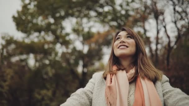 Movimiento lento de la mujer lanzando hojas de otoño. Noviembre. Ella disfrutando y sonriendo . — Vídeo de stock