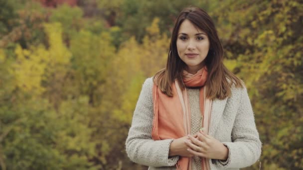 Felice giovane donna sorridente ritratto in autunno giorno contro sfondo fogliame giallo, rallentatore — Video Stock