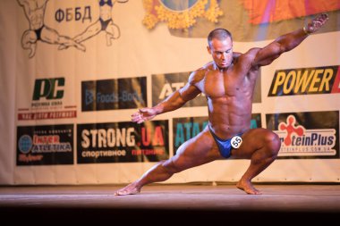 Ukrayna, Dnepr - 08 Ekim 2017: Vücut geliştirme Yarışması show. Açılan Şampiyonası. Güçlü musculars sporcu adam bir sahnede poz.