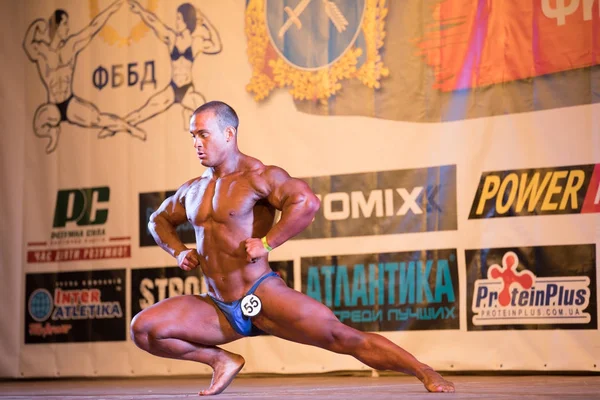 Oekraïne, Dnepr - 08 oktober 2017: Bodybuilding competitie show. Geopende kampioenschap. Sterke spieren atleet man poseren op een podium. — Stockfoto