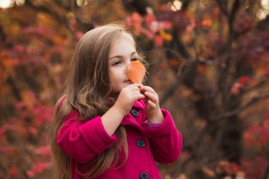 Kız sonbahar yaprak burnunu çekmek