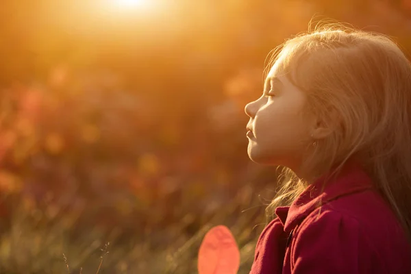 Little girl relaxing on sunset with closed eyes — Stock Photo, Image