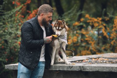 Adam köpeğiyle oynuyor.