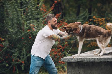 Adam köpeğiyle oynuyor.