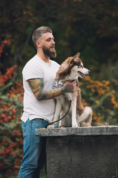 Hombre con estilo con tatuaje y perro —  Fotos de Stock