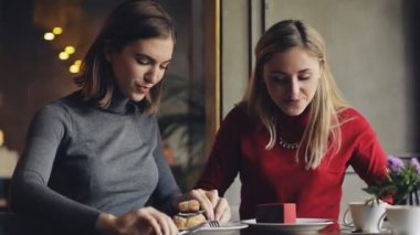 Kadın arkadaşlar, kafede kek yeme keyfini