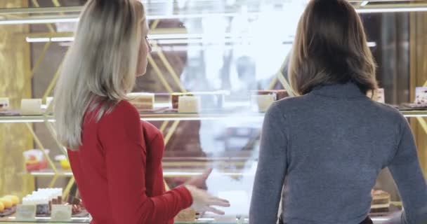 Twee meisjes keuze taart in café, achteraanzicht — Stockvideo