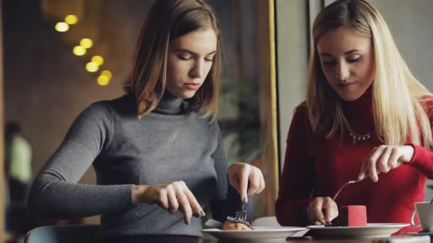 Жінки друзі розважаються, частуються один з одним в кафе — стокове відео