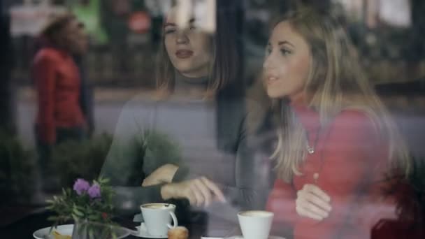 Друзья женщины ломаются в кафе, пьют кофе, смотрят в окно — стоковое видео