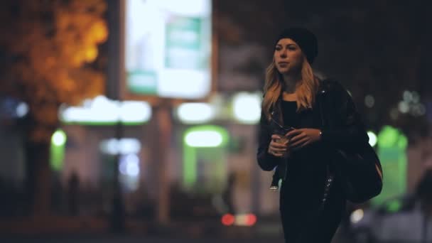 Mujer en la ciudad de noche cruzar una calle — Vídeo de stock