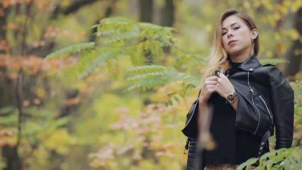 Rockige Frau posiert mit Lederjacke im Wald — Stockvideo