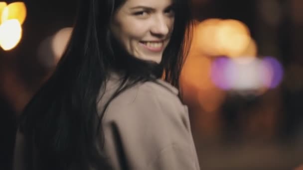 Atraktivní žena koketa pózuje na fotoaparátu v noční město, zpomalené — Stock video