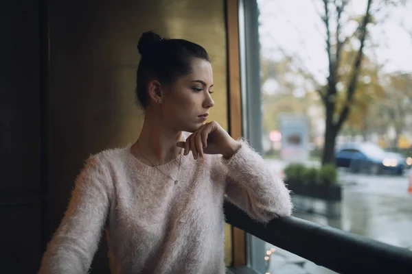 Chica tristemente pensamientos y mira a la ventana —  Fotos de Stock