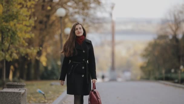Şehir sonbahar sokakta, slowmotion yürüyen kadın — Stok video