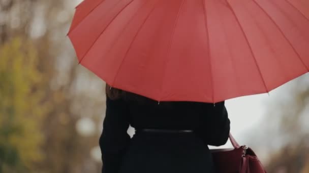 Donna che cammina sotto l'ombrello rosso, rallentatore — Video Stock