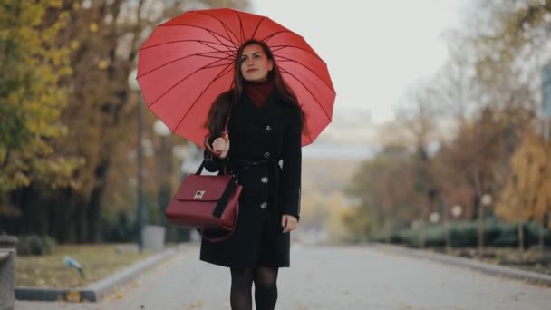Femme marchant sous le parapluie rouge, au ralenti 