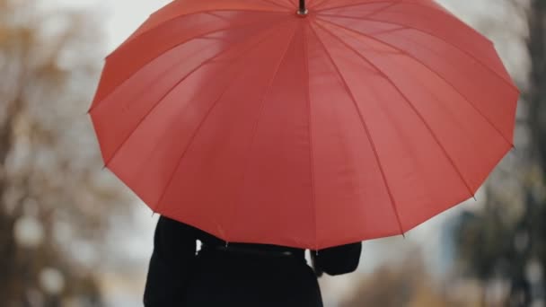 Mulher andando sob guarda-chuva vermelho, câmera lenta — Vídeo de Stock