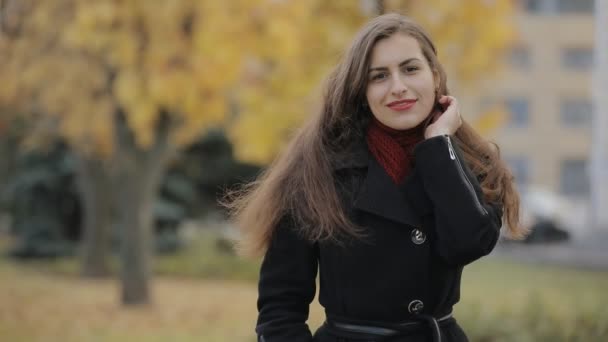 Slow motion porträtt av vacker kvinna ler i höstens city, verkliga mänskliga — Stockvideo