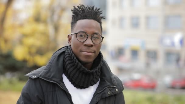 Hombre africano estudiante sonriendo retrato en fría ciudad de otoño europea — Vídeos de Stock