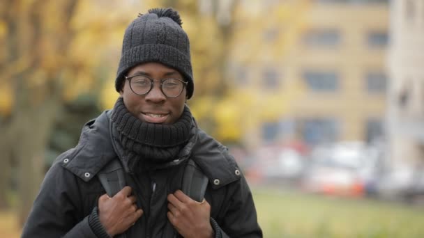 Hombre africano estudiante sonriendo retrato en fría ciudad de otoño europea — Vídeo de stock