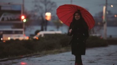 Kırmızı şemsiye altında yürüyen kadın