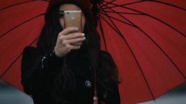 Mutlu kadın kırmızı şemsiye altında hareket eden fotoğraf olun