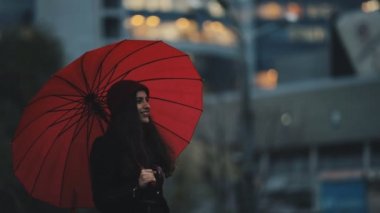 Şehir merkezinde yürüyüş kırmızı şemsiye altında mutlu kadın
