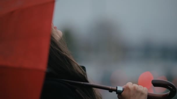 Donna felice sotto l'ombrello rosso guardando verso il cielo — Video Stock