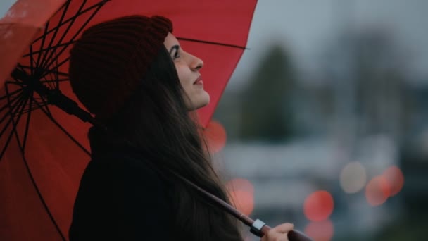 Ευτυχισμένη γυναίκα κάτω από την κόκκινη ομπρέλα, αναζητώντας τον ουρανό — Αρχείο Βίντεο
