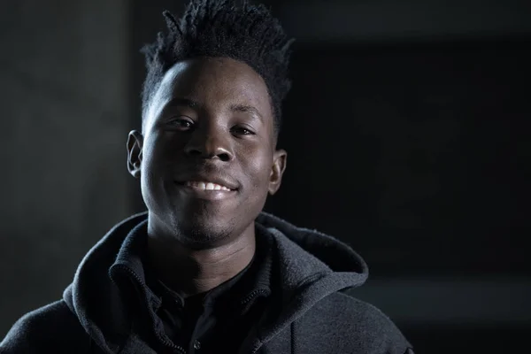 Африканский рэппер улыбающийся портрет в темноте — стоковое фото