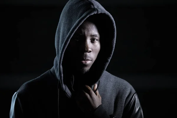 Африканский гангстер в капюшоне, в темноте — стоковое фото