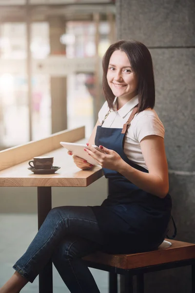 Barista sorrindo tendo coffee break, ela usando tablet PC — Fotografia de Stock