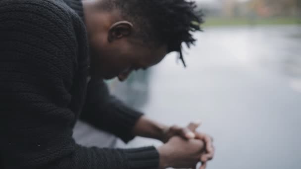 African man sitting on bench in basketball court — Stock Video