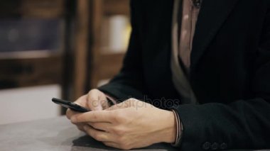 İşadamı kafede kullanın mobil akıllı telefon ve gülümseyerek kameraya, ağır çekim