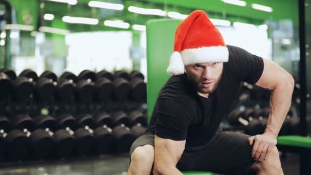 Gym, mannen i Santa hatt pumpning bicep — Stockvideo