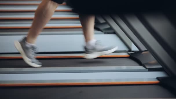 Чоловік біжить на біговій доріжці — стокове відео