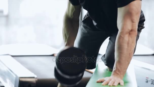 Чоловік накачує залізо в спортзалі — стокове відео