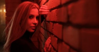 Seksi kadın kırmızı ışık duvara poz