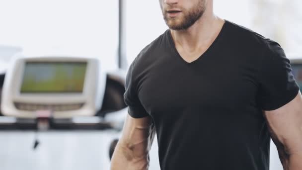 Man liften een halter in sportschool, hij pompt biceps — Stockvideo