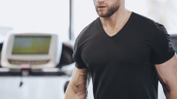 Mann hebt Hantel im Fitnessstudio, er pumpt Bizeps — Stockvideo